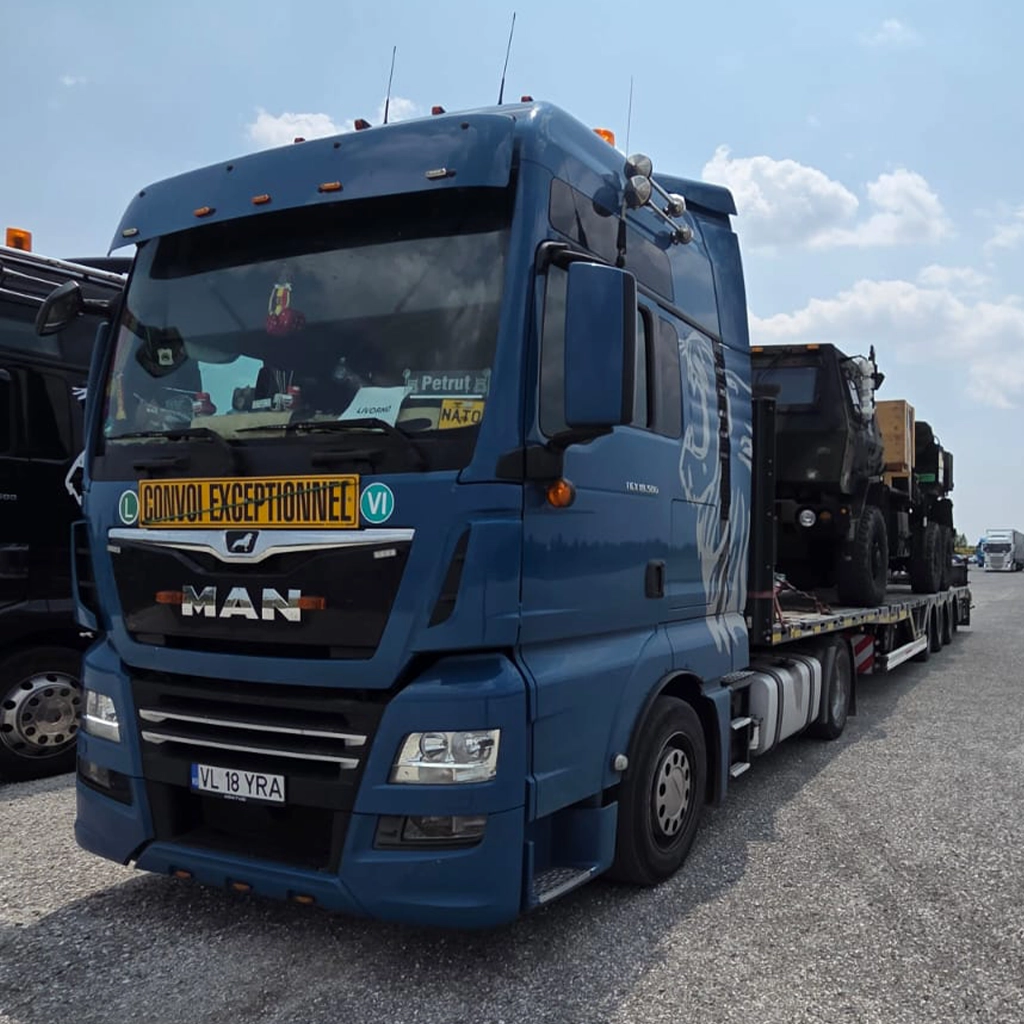 Camion MAN albastru transport agabaritic cu semiremorcă încărcată - servicii logistice specializate